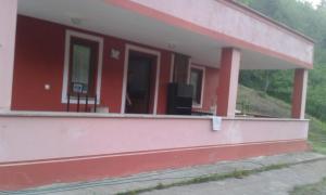 a red house with a balcony with a tv on it at Ayten's Sweet House in Trabzon