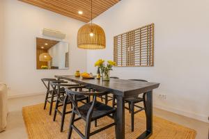 une salle à manger avec une table et des chaises noires dans l'établissement Luxury Top Villa Alhambra Pool close to Sea and Centre, à Benalmádena