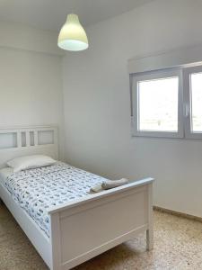 a white bedroom with a bed and a window at UIM Mediterraneo Emilio Llopis Wifi in Sagunto