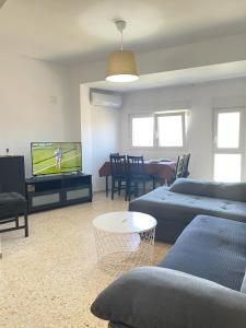 a living room with a couch and a tv and a table at UIM Mediterraneo Emilio Llopis Wifi in Sagunto