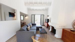 ein Wohnzimmer mit einem Sofa und einem Kamin in der Unterkunft Villa Everblue Sainte-Maxime - Domaine privé - Piscine in Sainte-Maxime