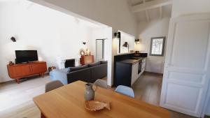 ein Wohnzimmer mit einem Tisch und einem Sofa sowie eine Küche in der Unterkunft Villa Everblue Sainte-Maxime - Domaine privé - Piscine in Sainte-Maxime