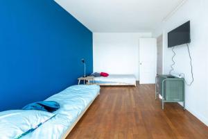 Habitación azul con cama y TV en Cénoslocs - Paris à vos pieds pour 6 pers., en Noisy-le-Sec