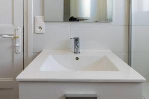y baño con lavabo blanco y espejo. en Cénoslocs - Paris à vos pieds pour 6 pers., en Noisy-le-Sec