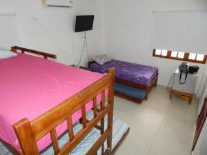a bedroom with two bunk beds and a tv at HABITACIONES EN casa de playa in Coveñas