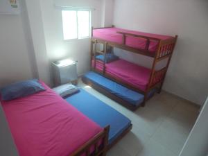 a bedroom with two bunk beds and a window at HABITACIONES EN casa de playa in Coveñas