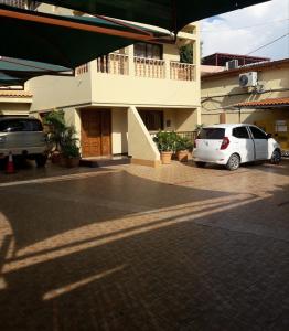 a white car parked in a parking lot in front of a building at CHIP RESIDENCIAL in Luanda