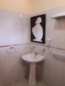 La salle de bains est pourvue d'un lavabo et d'une photo murale. dans l'établissement CHIP RESIDENCIAL, à Luanda