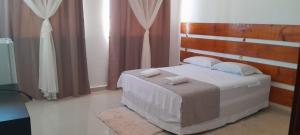 a bedroom with a bed with a wooden headboard at Central Palace Hotel in Fortaleza