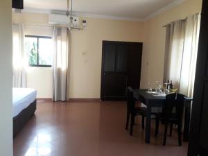 a dining room with a table and chairs and a bed at CHIP RESIDENCIAL in Luanda