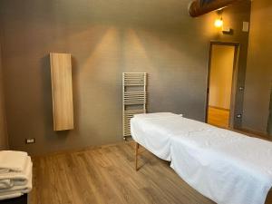 a bedroom with a white bed and a wooden floor at San Antonio Chalet in Padola