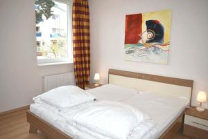 łóżko w sypialni z obrazem na ścianie w obiekcie Seepassage Ferienwohnung Nr 03 w mieście Timmendorfer Strand