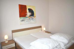 łóżko w sypialni z obrazem na ścianie w obiekcie Seepassage Ferienwohnung Nr 03 w mieście Timmendorfer Strand