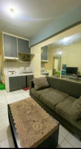 un soggiorno con divano e una cucina di Apartemen Cibubur village by ipol a Cisalak