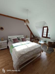 een slaapkamer met een groot bed in een kamer bij ESCAPADE BELINOISE in Moncé-en-Belin