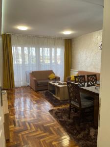 ein Wohnzimmer mit einem Tisch und einem Sofa in der Unterkunft Stan u centru, Loznica in Loznica