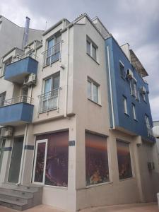 un grand bâtiment avec des ornements bleus et des fenêtres dans l'établissement MDM APARTMENT CITY CENTER, à Ruse