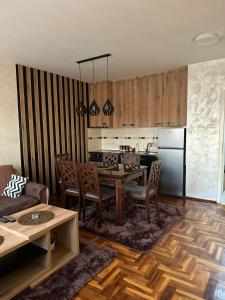 a kitchen and living room with a table and a refrigerator at Stan u centru, Loznica in Loznica