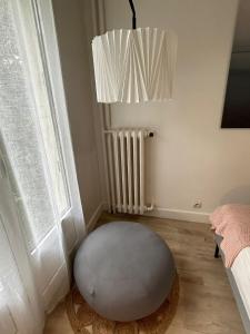 a room with a ottoman in front of a window at Cosy appartement Boulogne in Boulogne-Billancourt