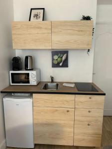 a kitchen with a sink and a microwave at Cosy appartement Boulogne in Boulogne-Billancourt