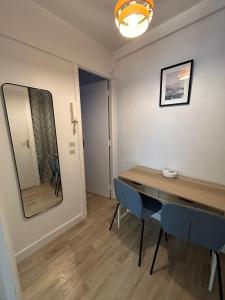 comedor con mesa, sillas y espejo en Cosy appartement Boulogne en Boulogne-Billancourt