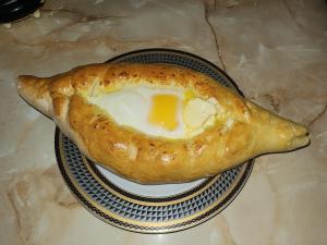 a fried egg in a bagel on a plate at Karavani in Ambrolauri