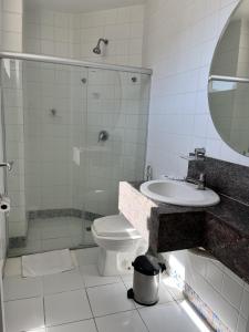 a bathroom with a toilet and a sink and a shower at Tropical Palace Hotel in Lavras