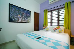 a bedroom with a bed and a tv on the wall at Kaippillil apart hotel in Ernakulam