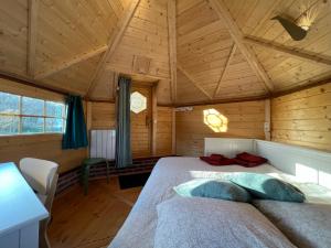 1 dormitorio con 1 cama en una cabaña de madera en Ô Saveur de l’Instant, en Saint-Usuge