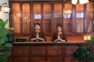 dwie kobiety siedzące w barze medytujące w obiekcie Phongsavath Boutique Hotel w mieście Wientian