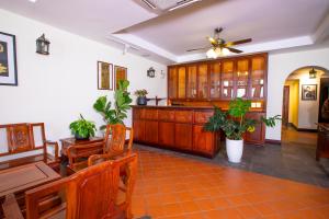 uma sala de jantar com mobiliário em madeira e uma ventoinha de tecto em Phongsavath Boutique Hotel em Vientiane