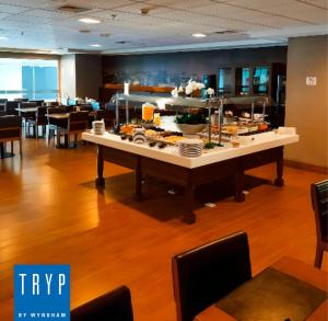 a buffet table with food on it in a restaurant at TRYP BY WYNDHAM São Paulo Airport - Hotel de Transito Terminal 3 -Lado Ar - Área restrita á passageiros já embarcados - Piso 1 in Guarulhos