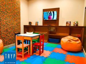 a room with a table and two chairs and a tv at TRYP BY WYNDHAM São Paulo Airport - Hotel de Transito Terminal 3 INTERNACIONAL - Lado Ar - Área restrita á passageiros já embarcados e sem bagagens para despachar - Transit Hotel, only carry-on in Guarulhos