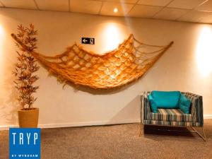 a hammock hanging on a wall next to a chair at TRYP BY WYNDHAM São Paulo Airport - Hotel de Transito Terminal 3 INTERNACIONAL - Lado Ar - Área restrita á passageiros já embarcados e sem bagagens para despachar - Transit Hotel, only carry-on in Guarulhos