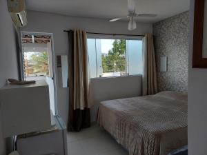 a bedroom with a bed and a window at Suíte Praia na casa da Berenice in Caraguatatuba