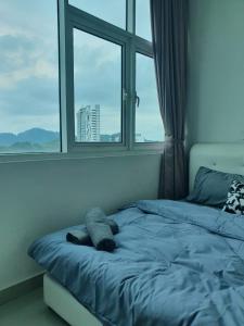 a bed in a room with a large window at Seaview Condo 10pax #10minQueensbay #15minSpice in Bayan Lepas