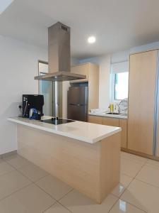 a kitchen with a counter with a stove top oven at Seaview Condo 10pax #10minQueensbay #15minSpice in Bayan Lepas