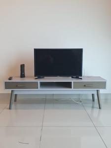 un centro de entretenimiento con TV de pantalla plana. en Seaview Condo 10pax #10minQueensbay #15minSpice, en Bayan Lepas