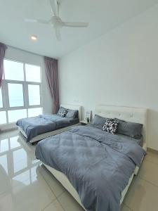 two beds in a room with two windows at Seaview Condo 10pax #10minQueensbay #15minSpice in Bayan Lepas