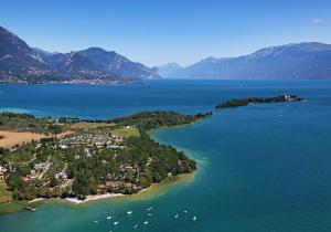 an island in the middle of a large body of water at Fornella Camping & Wellness family resort in San Felice del Benaco