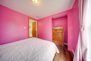 een slaapkamer met roze muren en een bed en een dressoir bij Flamingo Geneva Getaway Steps to Lake Erie! in Geneva