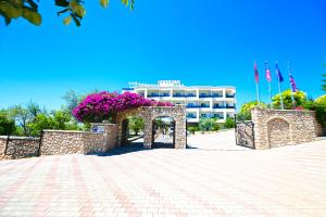 a building with purple flowers in front of it at Elysium Hotel in Dhërmi