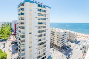 an aerial view of a tall white building next to the ocean at Vista Mar in Quarteira