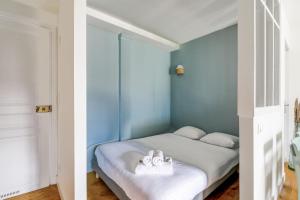 un dormitorio con paredes azules y una cama con zapatos. en Comfortable studio in the Grand Hôtel of Houlgate - Welkeys, en Houlgate