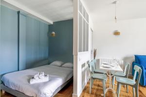 1 dormitorio con 1 cama y 1 mesa con sillas en Comfortable studio in the Grand Hôtel of Houlgate - Welkeys, en Houlgate