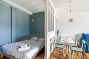 a bedroom with a bed and a table with chairs at Dans l'ancien Grand Hôtel charmant studio in Houlgate