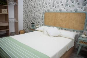 - une chambre avec un lit blanc et une grande tête de lit dans l'établissement Holiday House ViscaUno, à Nettuno
