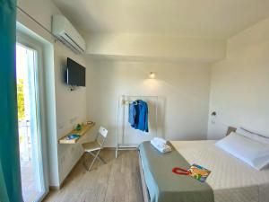 a room with a bed and a desk and a window at Campus Dei - Tropea Rooms in Tropea