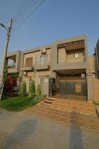 een huis met een poort en een trap ervoor bij Grey Orchard Homestay - A Family Place in Lahore