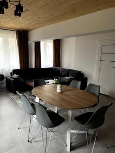 a living room with a wooden table and chairs at Nowy apartament dla 6 osob in Krynica Zdrój